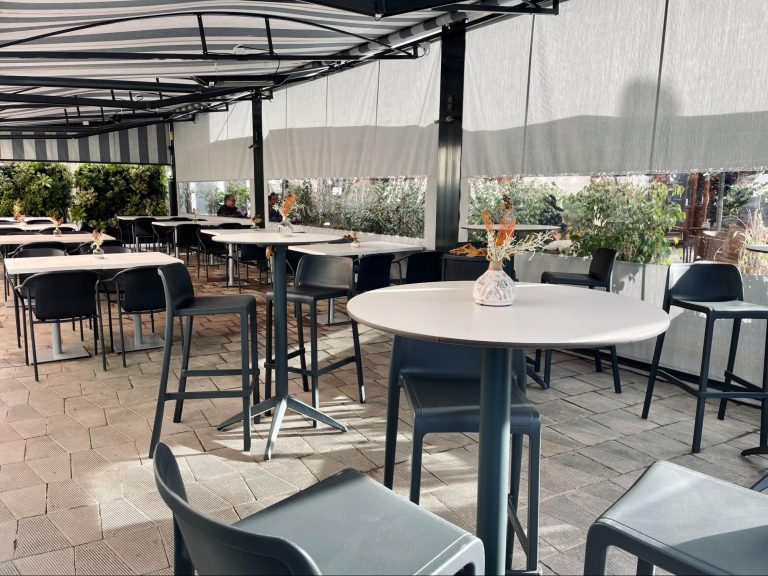 Mesa alta con taburetes en terraza